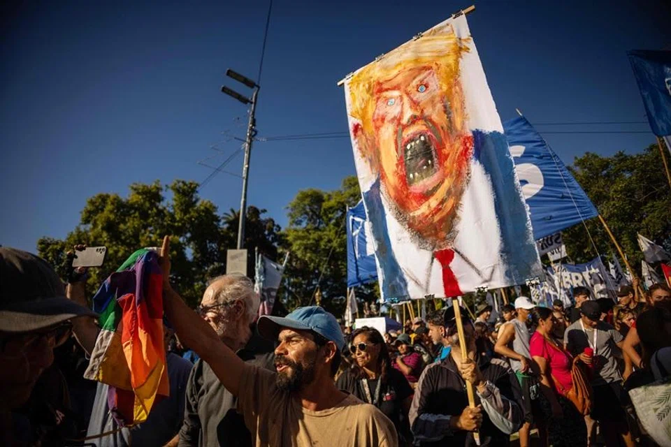 A man holds a painting depicting US President Donald Trump during a protest against the US intervention in Venezuela, in Buenos Aires on 5 January 2026. (Tomas Cuesta/AFP)