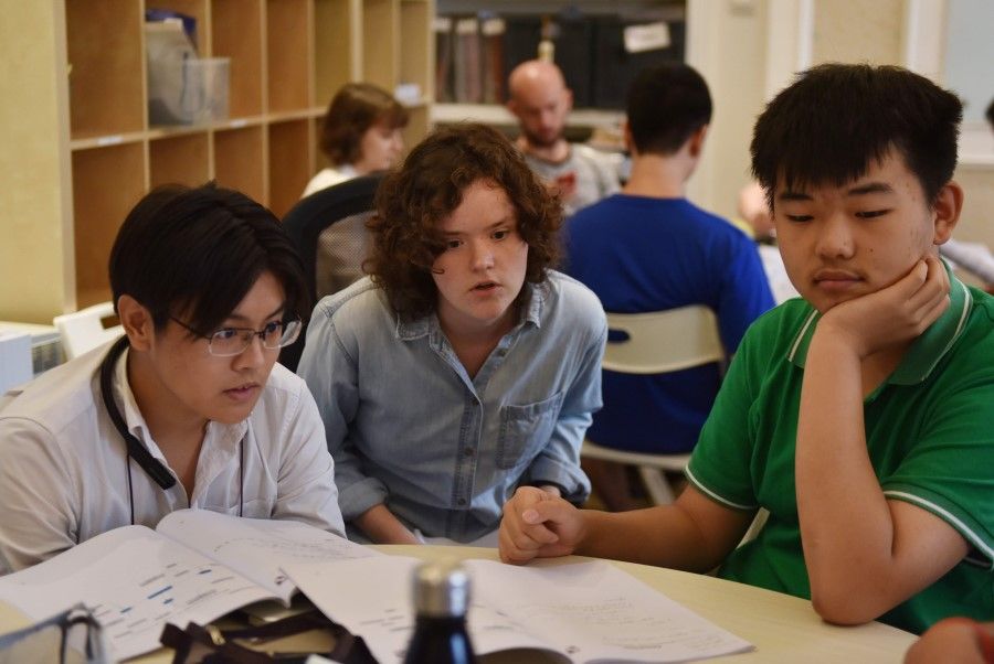 This photo taken on 19 July 2019 shows college counsellor Mackenzie Bell (centre) speaking with students during a class at Elite Scholars of China (ESC), a boutique college consultancy in Beijing where students can receive application guidance, mentoring, and advice on the best courses for their interests and skills. China accounts for nearly a third of foreign students on US campuses. (AFP)