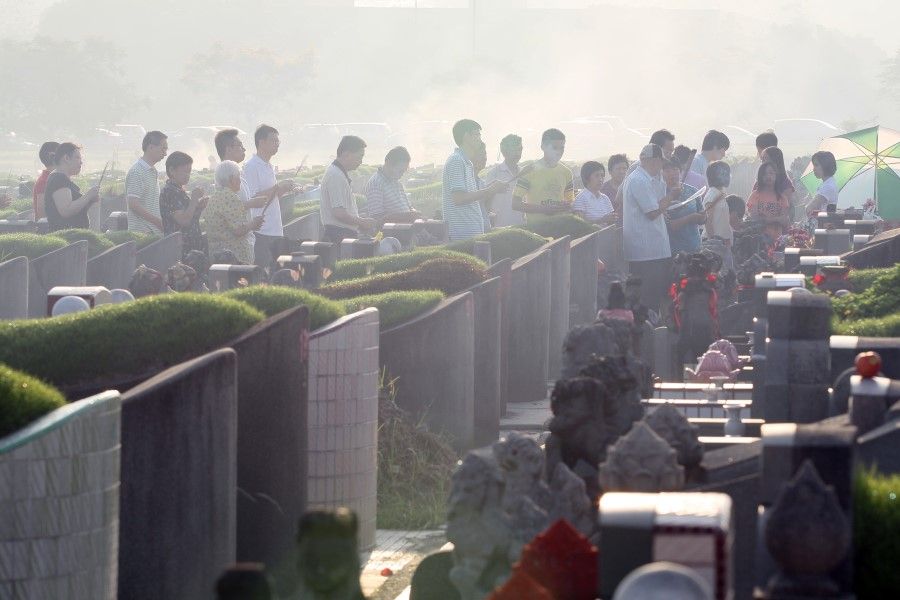 People paying respects at the graves in Choa Chu Kang Cemetery. (SPH Media)