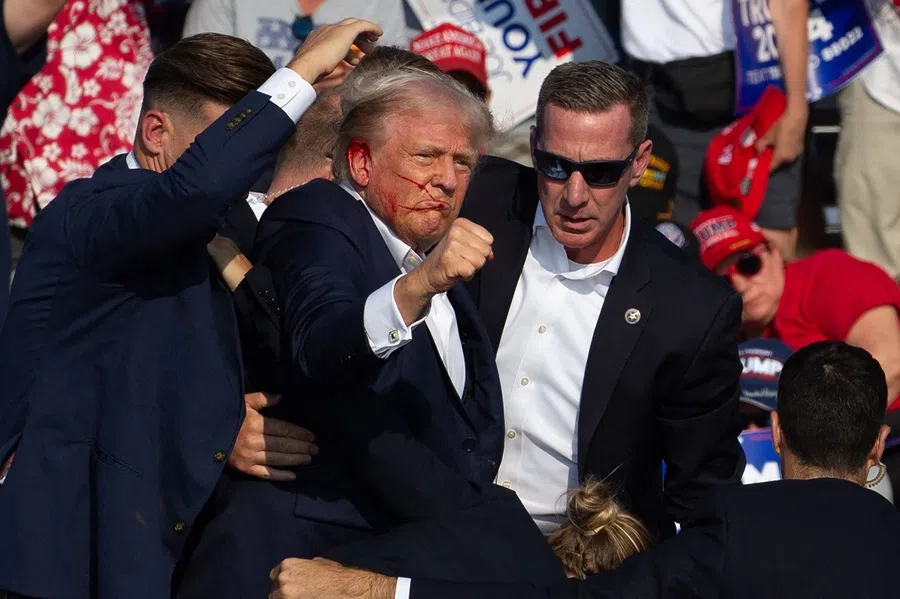 US Republican candidate Donald Trump is seen with blood on his face surrounded by Secret Service agents as he is taken off the stage at a campaign event at Butler Farm Show Inc. in Butler, Pennsylvania, US, on 13 July 2024. (Rebecca Droke/AFP)