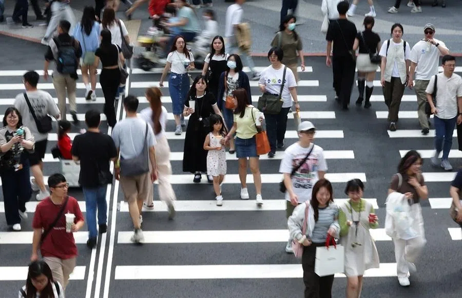 Pedestrians cross a street in Zhongshan District, Taipei, Taiwan April 11, 2026. REUTERS/Edgar Su