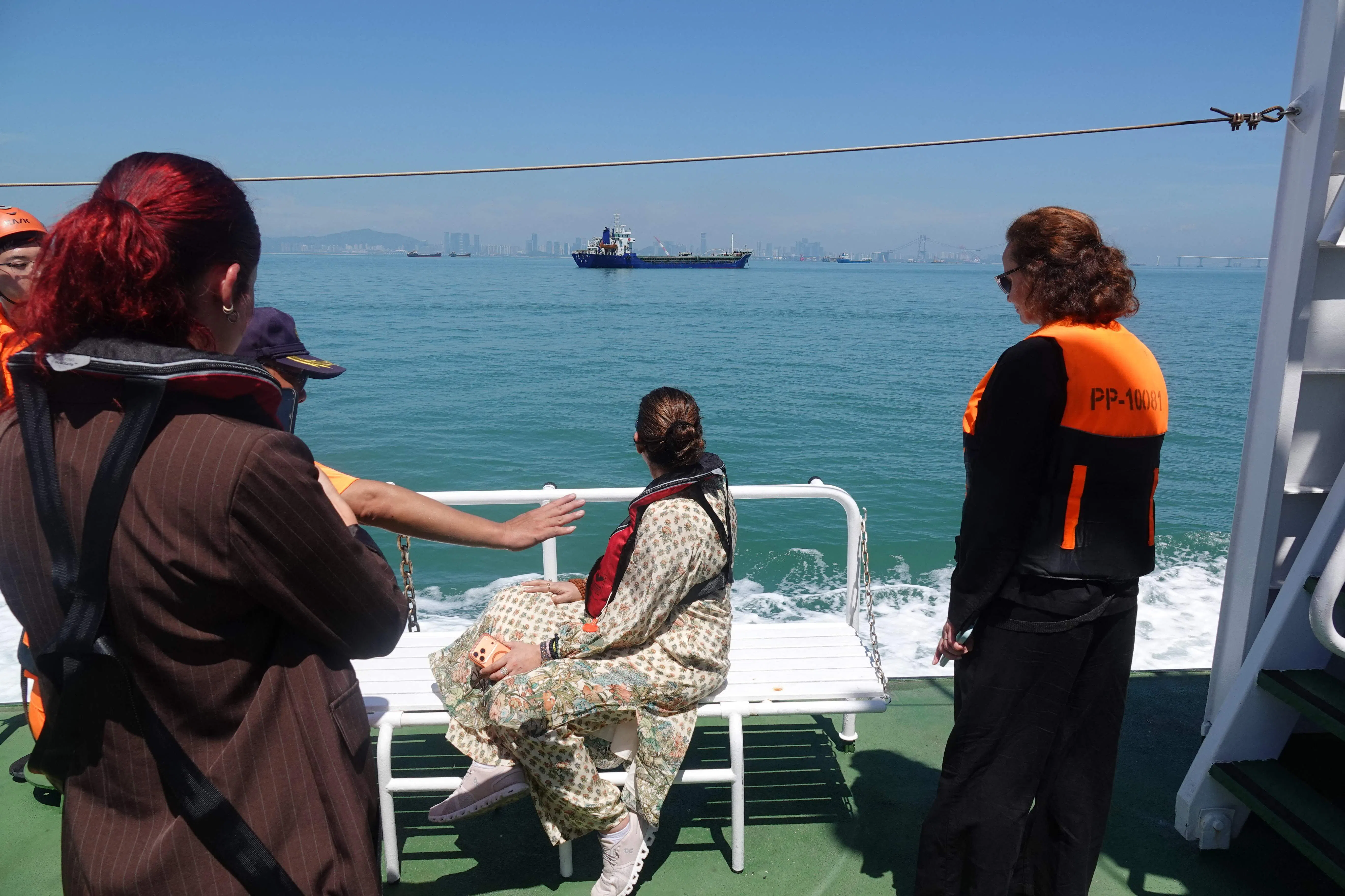 This picture taken and released by Taiwan’s Central News Agency (CNA) on 9 July 2026 shows members of a delegation from the Inter-Parliamentary Alliance on China (IPAC) on board a Taiwan Coast Guard patrol vessel as a Chinese civilian vessel is seen in the distance in Kinmen, Taiwan.