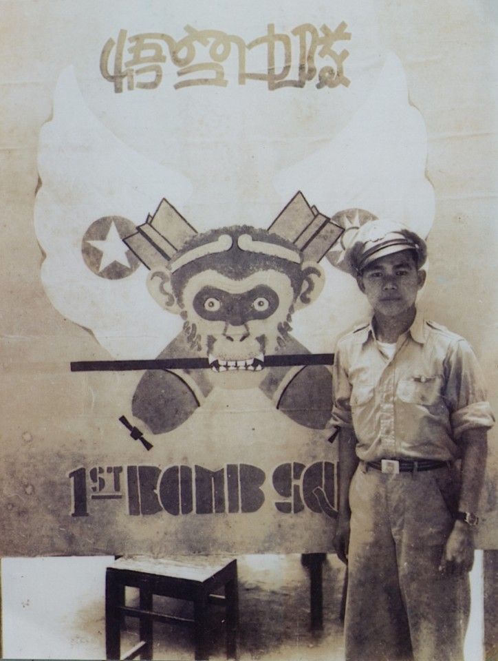 Ho in his standby duties attire, standing in front of our 1st Bomb Squadron, Chinese American Composite Wing insignia, the Monkey God emblem, Hanchung, 1945.