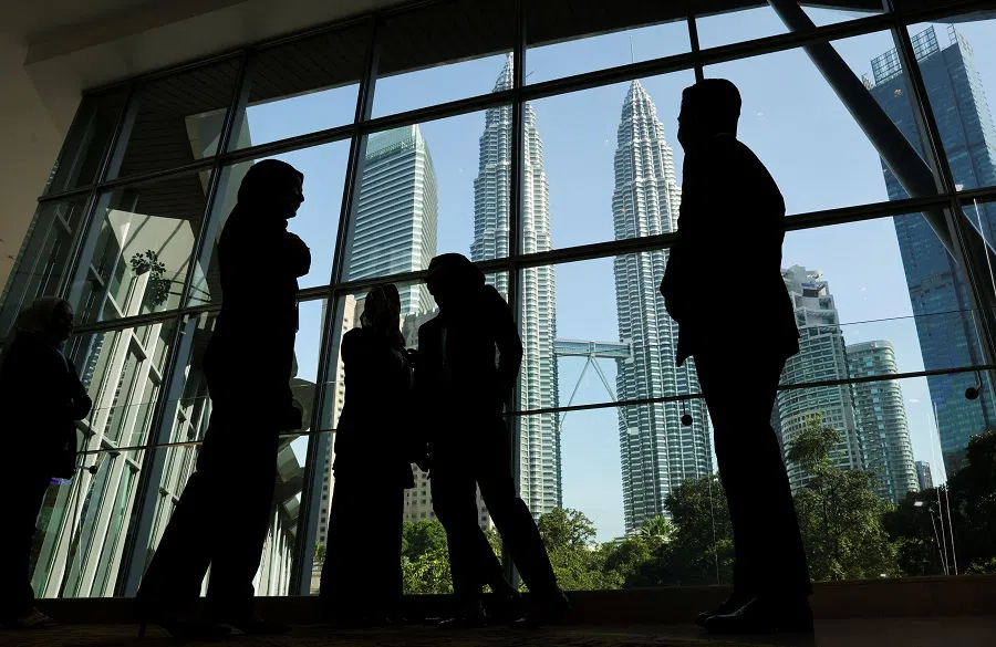 Silhouettes of people are seen with the Petronas Twin Towers in the background in Kuala Lumpur, Malaysia, on 9 April 2025. (Hasnoor Hussain/Reuters)