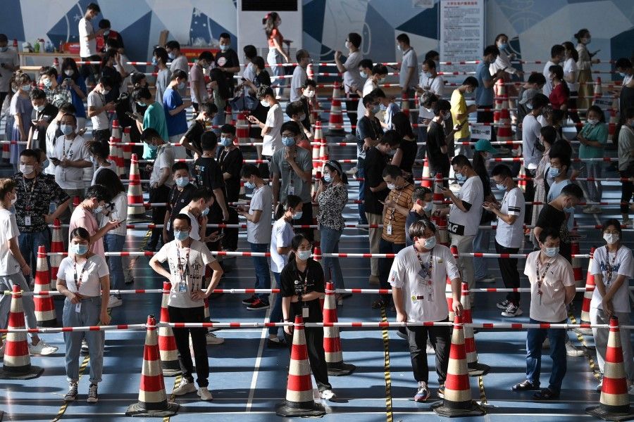 This photo taken on 5 August 2021 shows staff queueing to test for the Covid-19 coronavirus at the gym of a company in Wuhan in China's central Hubei province. (STR/AFP)