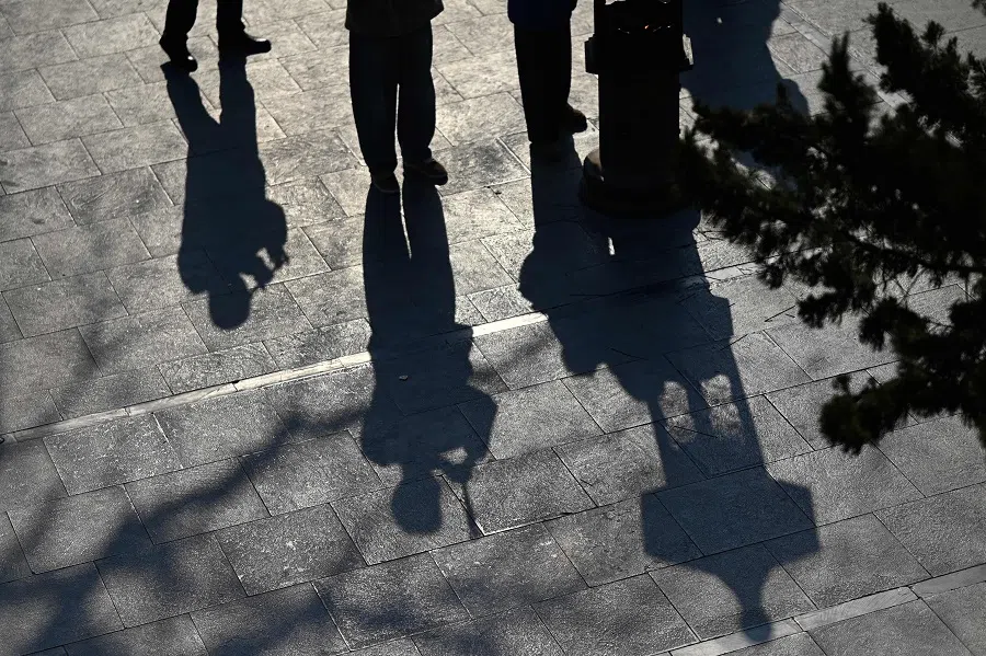 Shadows of people holding incense sticks and offering prayers are seen at the Baiyun Taoist Temple, also known as the White Cloud Temple, in Beijing on 23 January 2025.