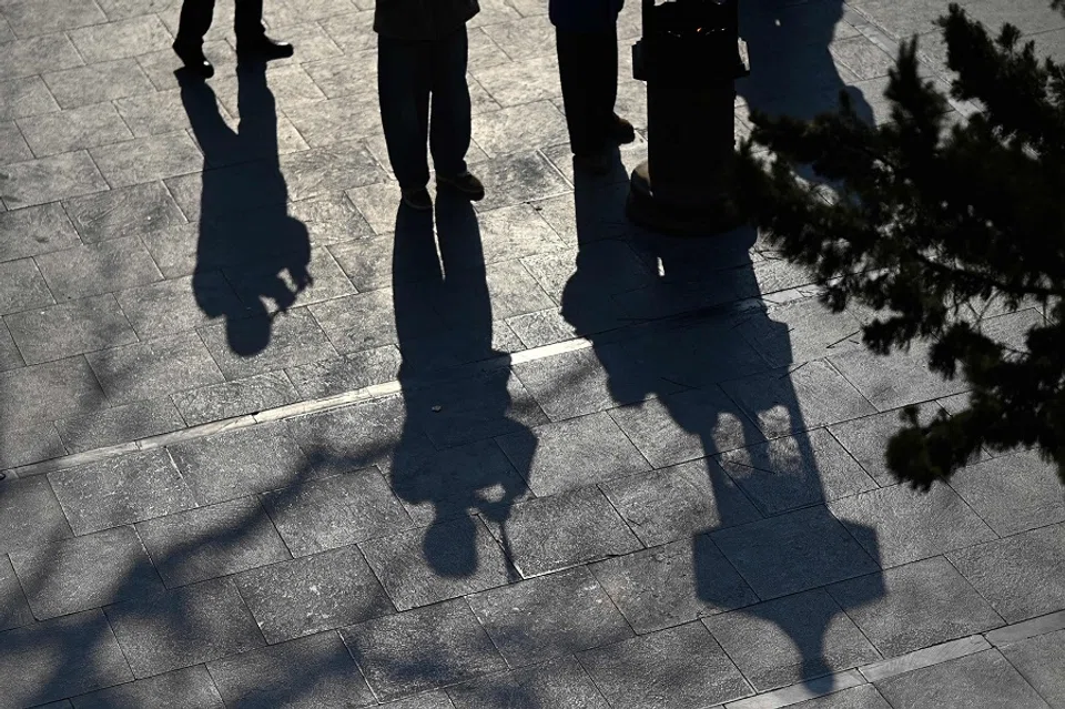 Shadows of people holding incense sticks and offering prayers are seen at the Baiyun Taoist Temple, also known as the White Cloud Temple, in Beijing on 23 January 2025. (Pedro Pardo/AFP)