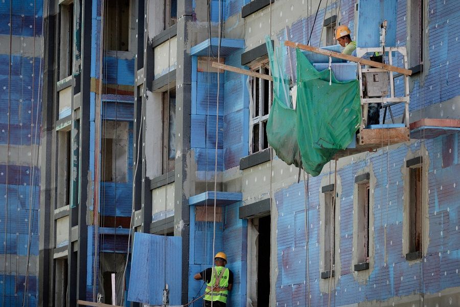 Men work at a construction site of apartment buildings in Beijing, China, 15 July 2022. (Thomas Peter/File Photo/Reuters)