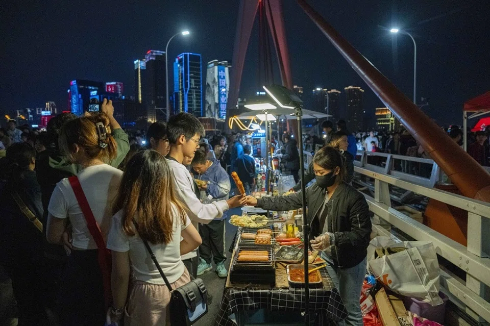 Customers buy food from street stalls in Chongqing, China, on 2 May 2024. (Raul Ariano/Bloomberg)