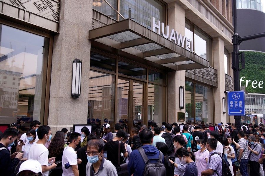 People stand in line in front of Huawei's new flagship store in Shanghai, 24 June 2020. (Aly Song/REUTERS)
