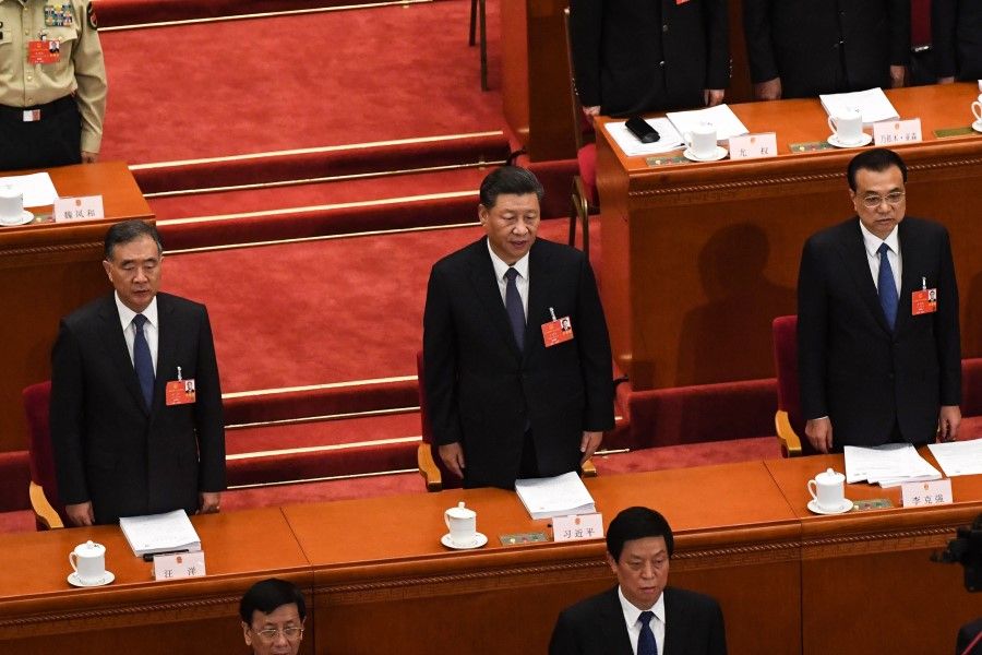 Chinese President Xi Jinping (C), Premier Li Keqiang (R) and Politburo Standing Committee member Wang Yang (L) sing the national anthem during the opening session of the National People's Congress (NPC) at the Great Hall of the People in Beijing on May 22, 2020. (Leo Ramirez/AFP)