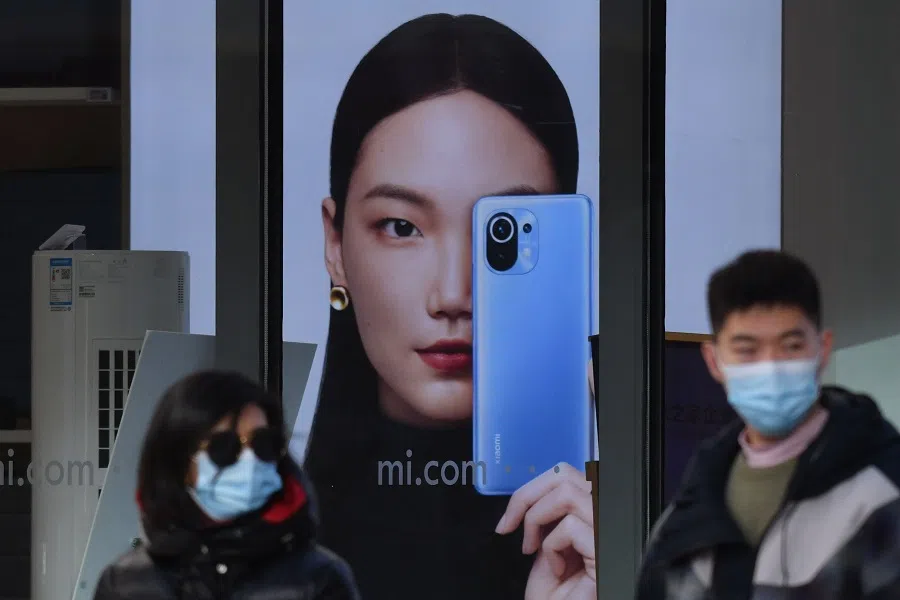 People walk past a Xiaomi store in Beijing on 15 January 2021, as shares in the company collapsed on January 15 after the United States blacklisted the smartphone giant and a host of other Chinese firms. (Greg Baker/AFP)