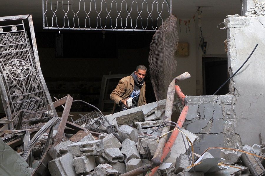 A man clears rubble from a damaged building following Israeli airstrikes in Rafah, southern Gaza Strip, on 12 February 2024. (Ahmad Salem/Bloomberg)
