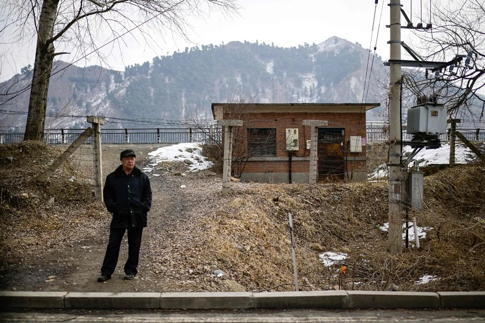 This photo taken on 29 February 2024 shows a man standing near the border with the North Korean province of Chagang in Linjiang in the province of Jilin, northeast China. (Pedro Pardo/AFP)