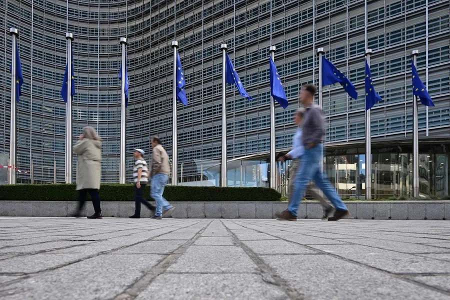 Pedestrians walk past the Berlaymont building, the EU Commission headquarters, in Brussels on 2 October 2026.