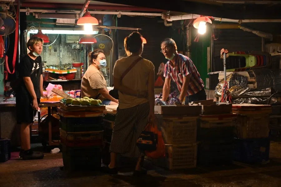 Market traders chat in Hong Kong on 31 May 2022. (Peter Parks/AFP)