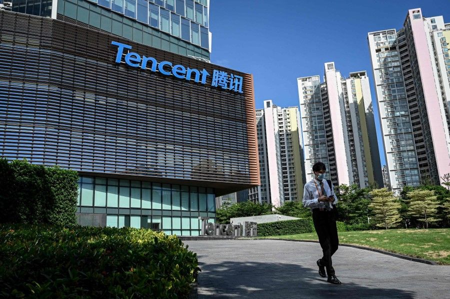 This file photo taken on 10 July 2022 shows a man walking past the Tencent headquarters in Shenzhen, in China's southern Guangdong province. (Jade Gao/AFP)