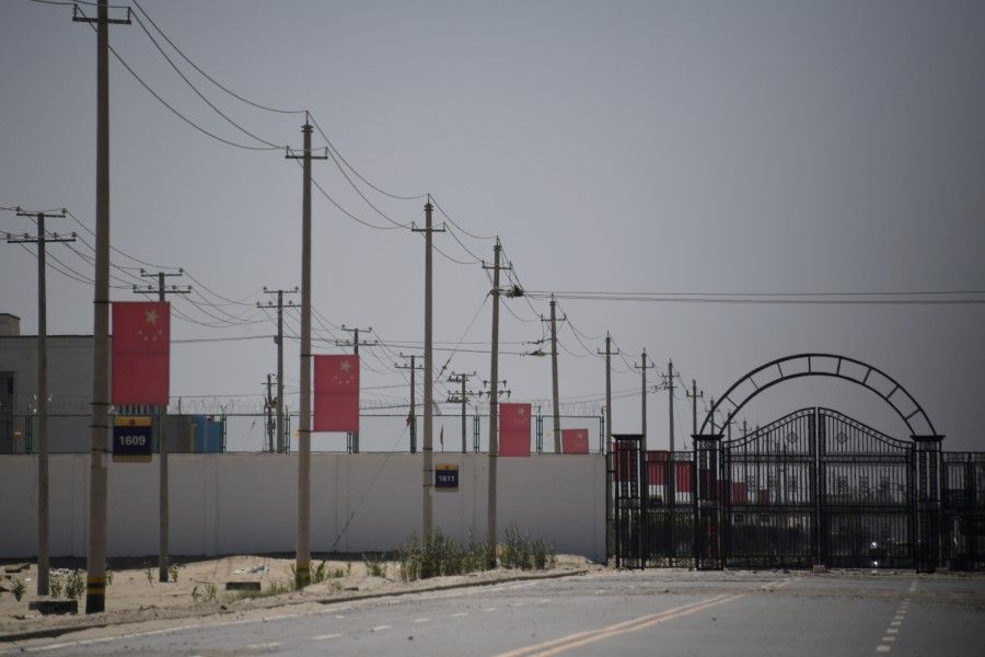 In this file photo taken on 31 May 2019, Chinese flags are seen on a road leading to a facility believed to be a re-education camp where mostly Muslim ethnic minorities are detained, on the outskirts of Hotan in China's northwestern Xinjiang region. The US, Japan and many EU nations joined a call on 6 October 2020, urging China to respect the human rights of minority Uighurs, and also expressing concern about the situation in Hong Kong. (Greg Baker/AFP)