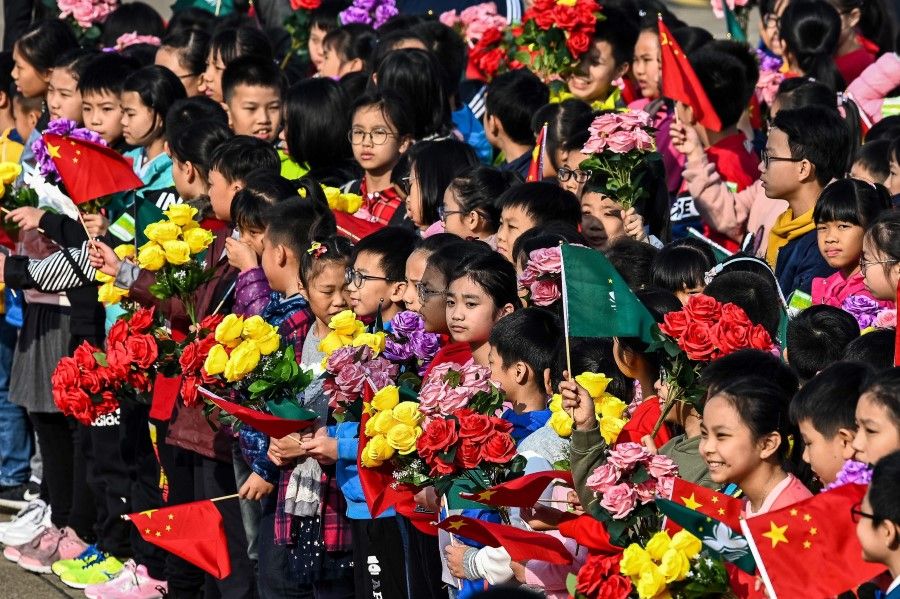 The Chinese system has governance capacity to tackle the emerging "troubled times". This picture shows children waiting to bid farewell to China's President Xi Jinping and his wife Peng Liyuan at the international airport in Macau on 20 December, 2019. (Photo by Eduardo Leal/AFP)