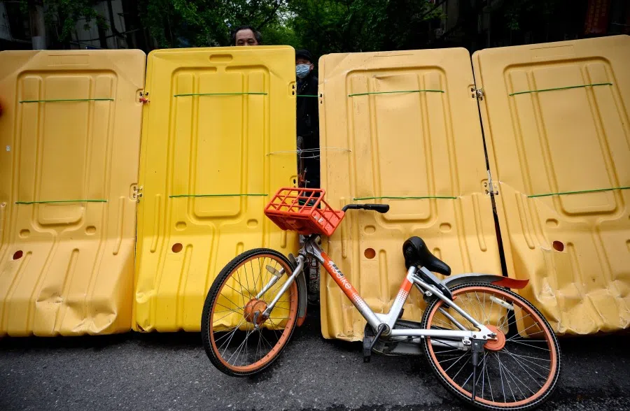 An elderly man looks over a barricade separating a residential compound in Wuhan, April 2, 2020. (Noel Celis/AFP)