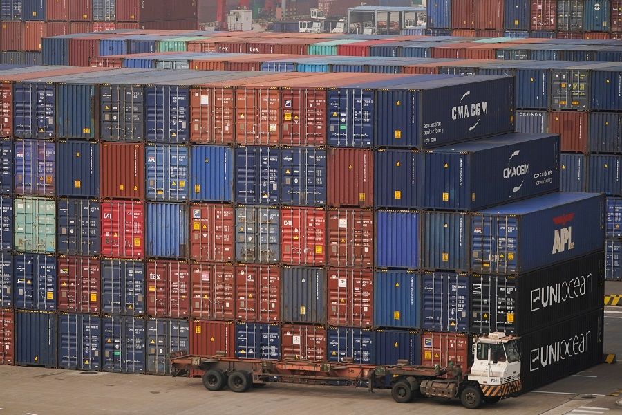 A truck is seen next to containers at the Yangshan Deep Water Port in Shanghai, China, 13 January 2022. (Aly Song/Reuters)