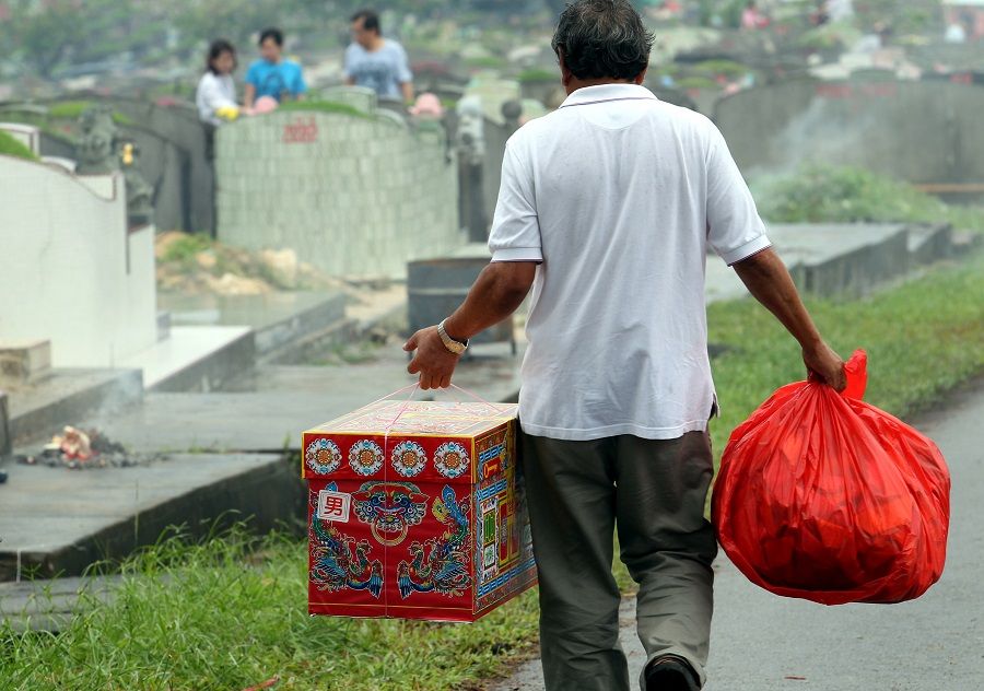 People make offerings at the graves of their ancestors during Qingming Festival in Singapore. (SPH)