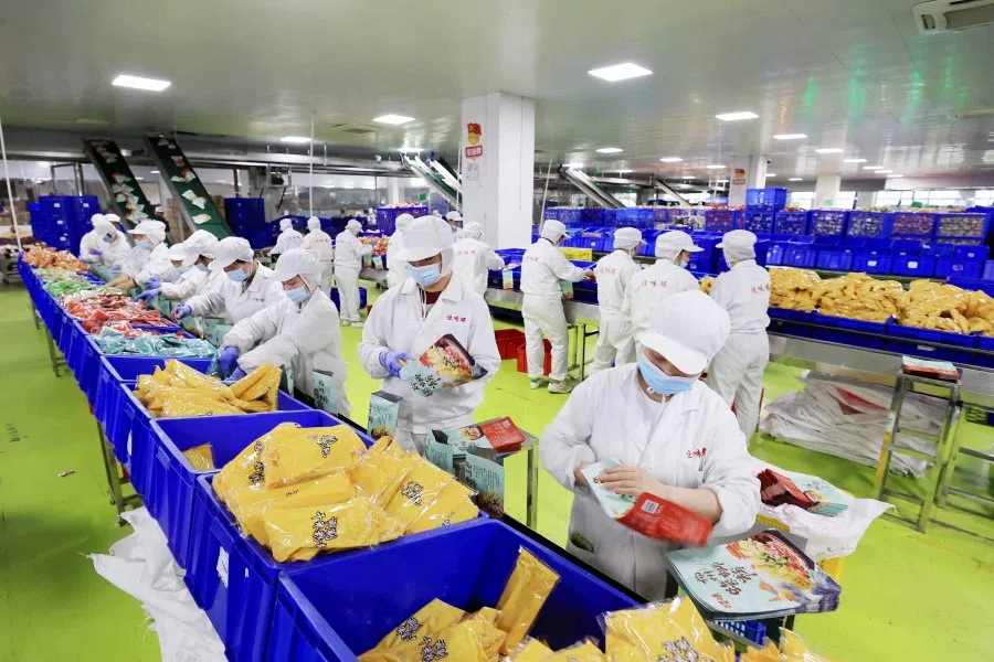 This photo taken on 29 March 2023 shows workers producing packaged snail rice noodles at a factory in Liuzhou, in China's southern Guangxi region. (AFP)