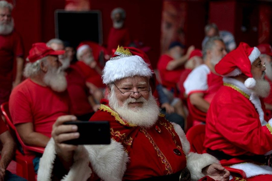 A group of professional Santa Claus wait to receive their Christmas food baskets during a charity event organized by Brazil's School of Santa Claus and a food distribution company, at the Estacio de Sa Samba School barrack in Rio de Janeiro, Brazil, on 20 December 2022. (Mauro Pimentel/AFP)