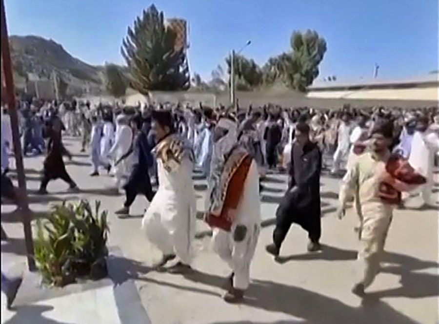 This image grab from a UGC video made available on 14 October 2022 shows Iranian protesters chanting slogans as they march on a street in Zahedan, Iran. (UGC/AFP)