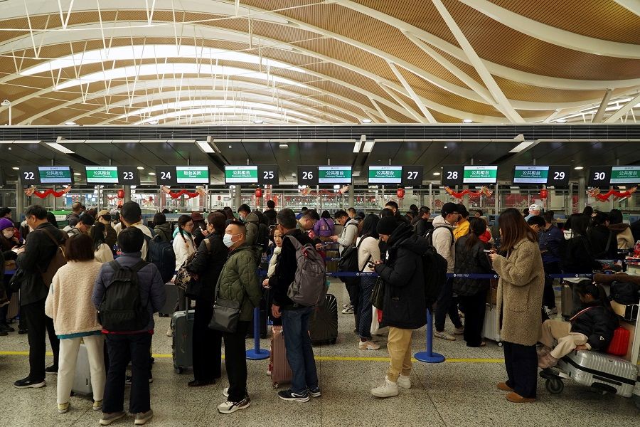 Travellers line up to check in at Shanghai Pudong International Airport in Shanghai, China, on 9 February 2024. (Nicoco Chan/Reuters)