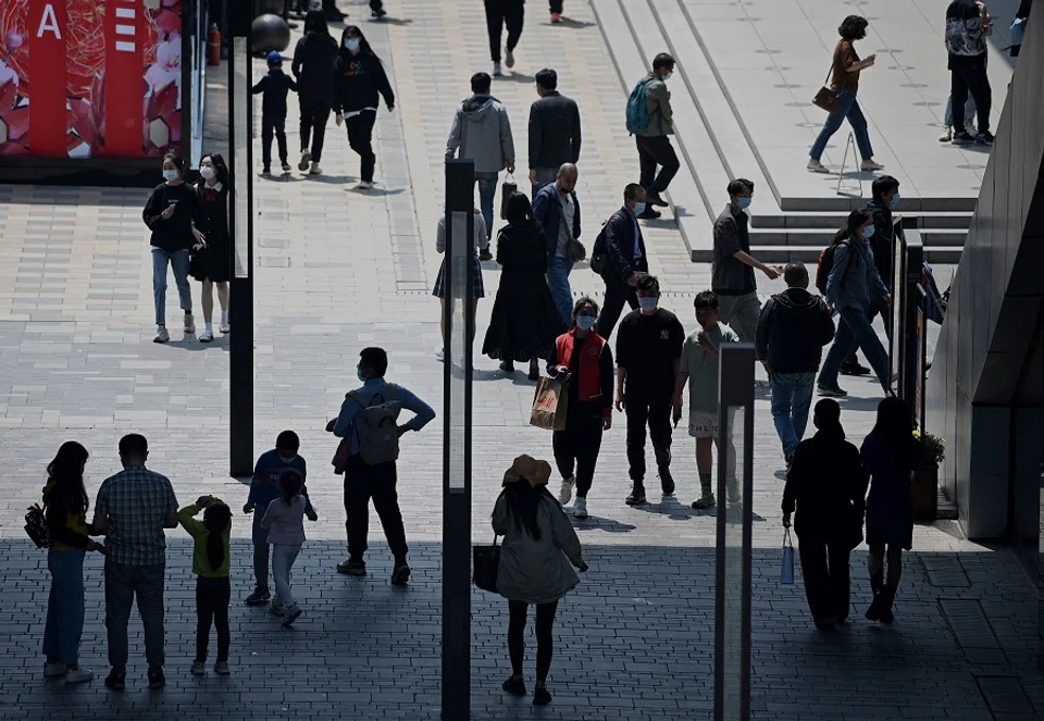 People walk along a shopping district during the Labour Day holidays, in Beijing, China, on 3 May 2021. (Noel Celis/AFP)