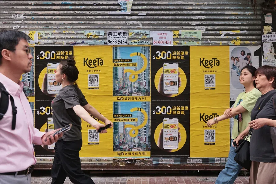 People walk past posters for Keeta in Hong Kong, on 22 May 2023. (Hong Kong China News Agency)