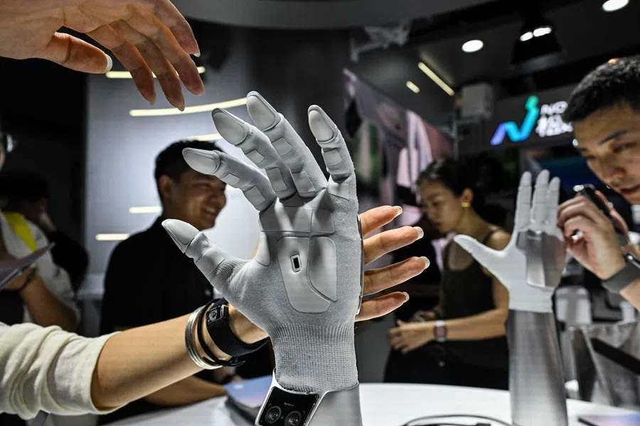 Visitors touch robotic hybrid-driver hands by Xynova Technology during the World Artificial Intelligence Conference (WAIC) in Shanghai on 18 July 2026.