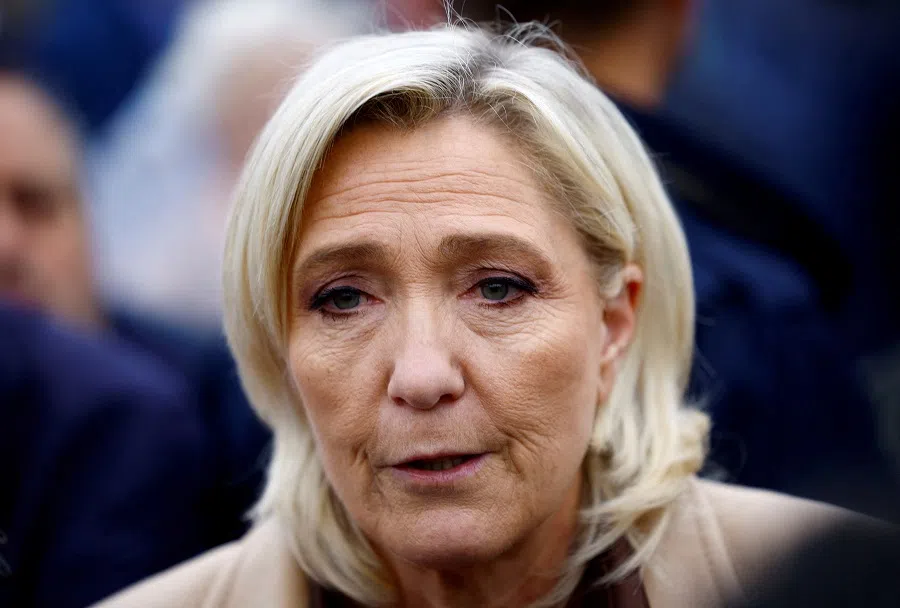 Marine Le Pen, French far-right leader and French far-right National Rally party candidate in the upcoming parliamentary elections, talks to journalists as she campaigns at a market in Henin-Beaumont, northern France, on 14 June 2024. (Sarah Meyssonnier/Reuters)