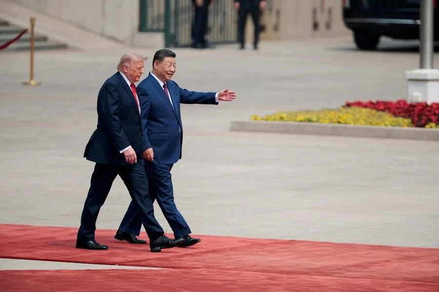 US President Donald Trump walks with Chinese President Xi Jinping upon arrival at the Great Hall of the People in Beijing, China, 14 May 2026. (Evan Vucci/Reuters)