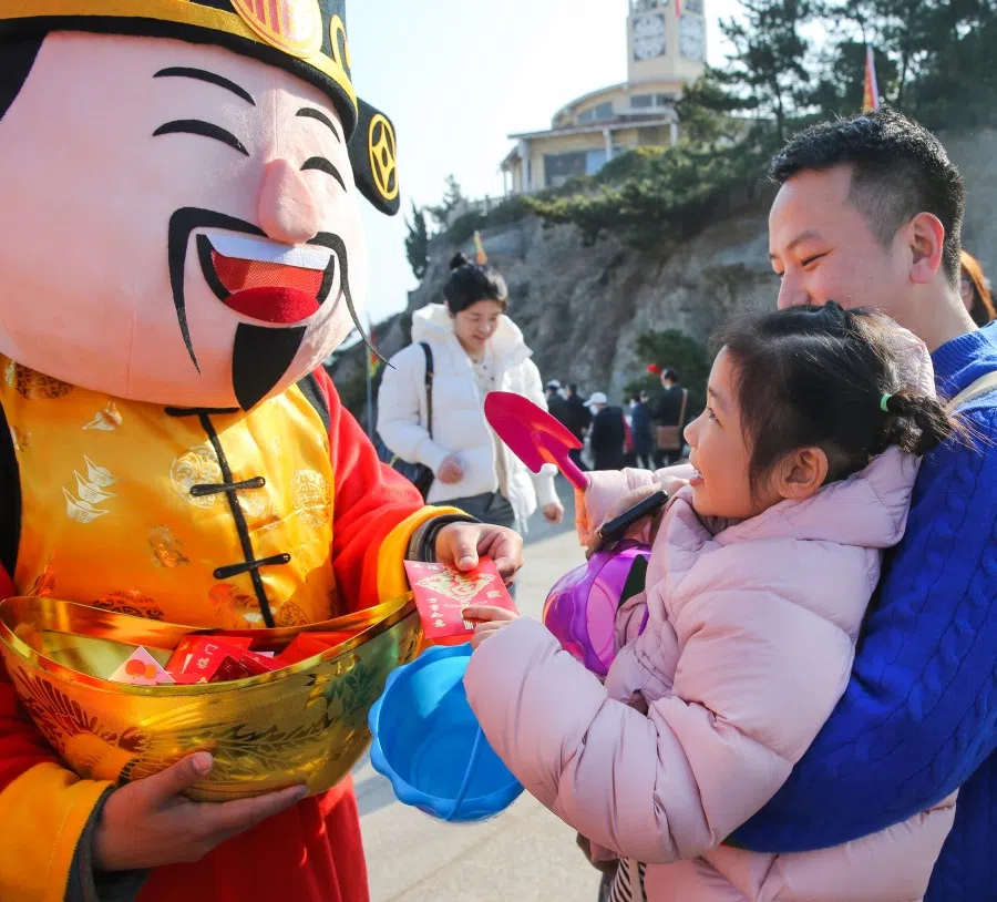 A God of Fortune distributes hongbaos to visitors at Liandao Scenic Area in Lianyungang city, Jiangsu province, on 14 February 2024. (Xinhua)