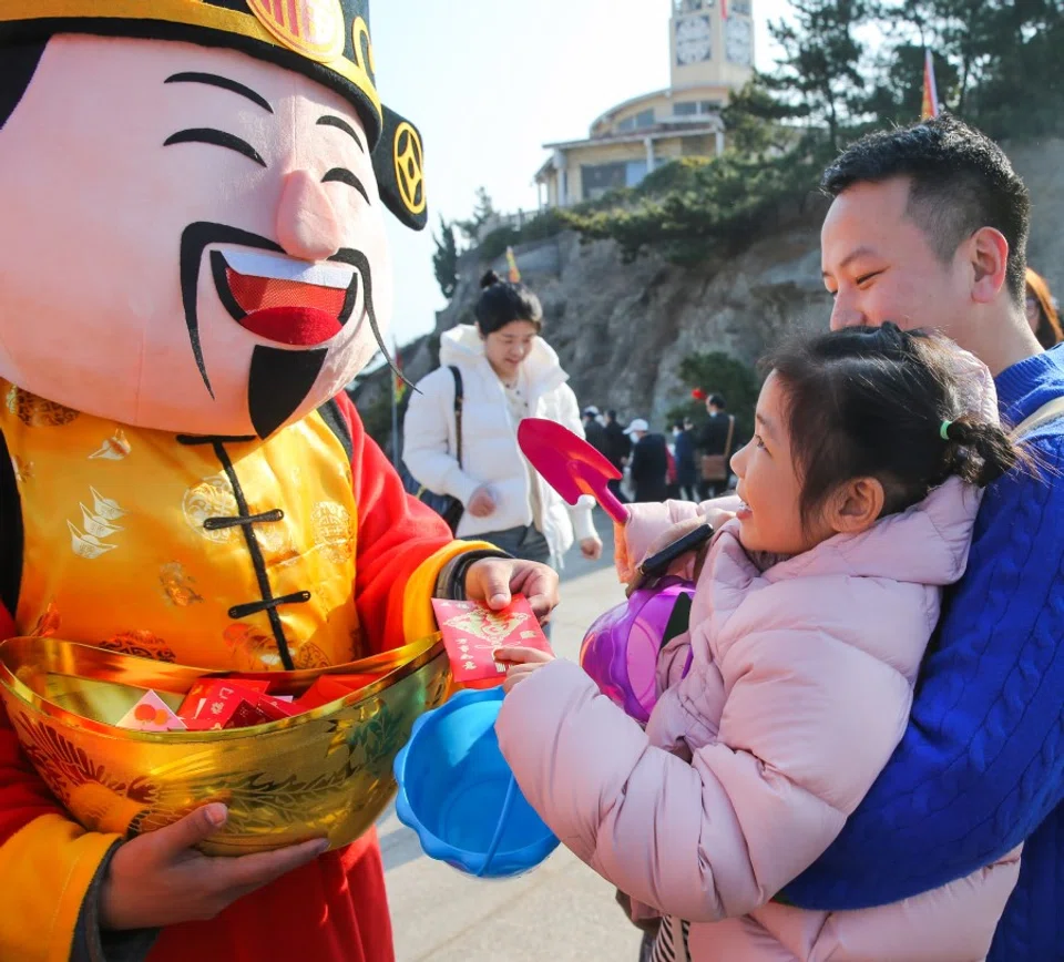 A God of Fortune distributes hongbaos to visitors at Liandao Scenic Area in Lianyungang city, Jiangsu province, on 14 February 2024. (Xinhua)