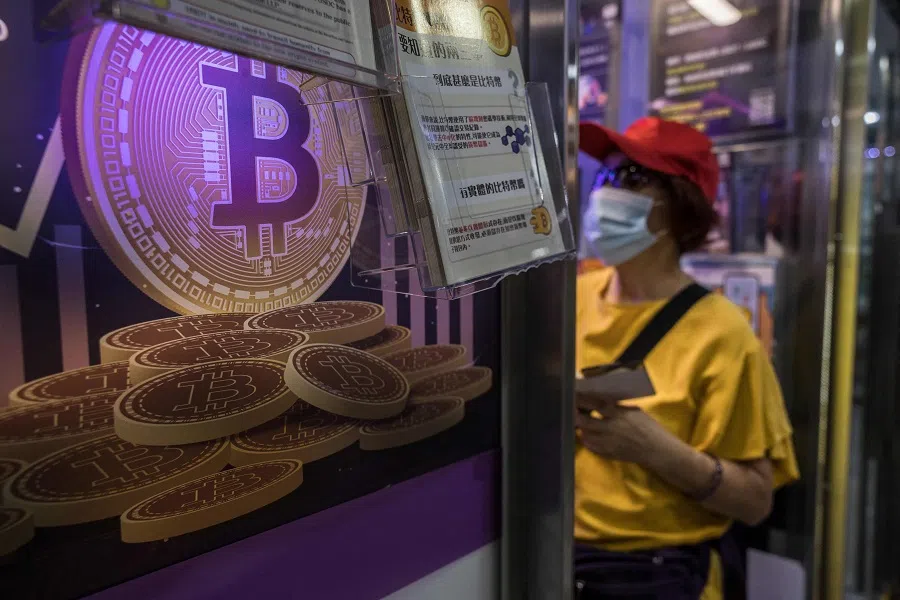 A woman speaks with a worker at a cryptocurrency exchange in Hong Kong on 15 April 2024. (Dale De La Rey/AFP)