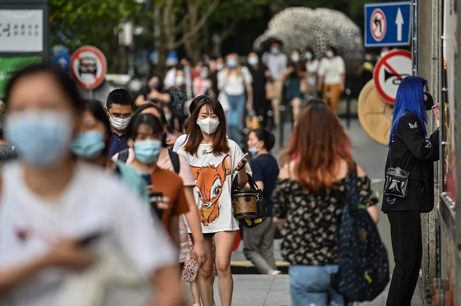 People walk on a street in Shanghai, China, on 5 August 2021. (Hector Retamal/AFP)