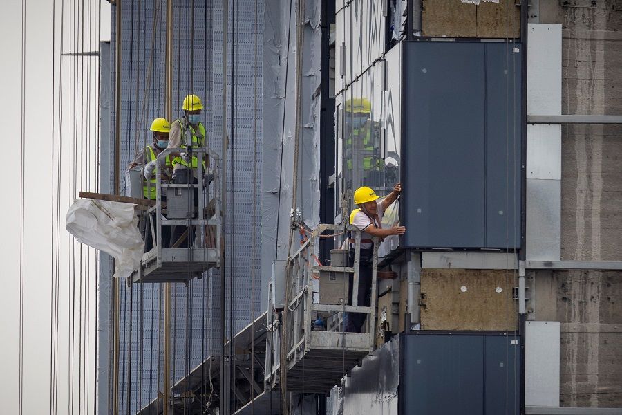 Men work at the construction site of an apartment building in Beijing, China, on 29 July 2023. (Thomas Peter/Reuters)