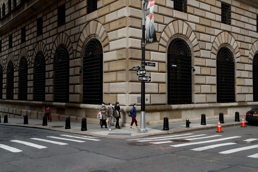 People walk outside the Federal Reserve Bank of New York in New York City, U.S., 18 March 2020. (Lucas Jackson/Reuters)