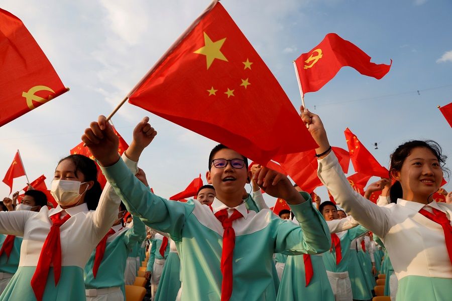 Performers wave national and party flags as they rehearse before the event marking the 100th founding anniversary of the Communist Party of China, at Tiananmen Square in Beijing, China, 1 July 2021. (Carlos Garcia Rawlins/Reuters)