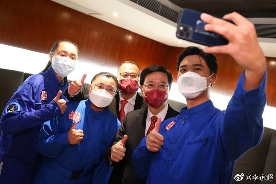 Hong Kong Chief Executive John Lee (second from right) with three former participants of the Hong Kong Space Museum's Young Astronaut Training Camp. (Weibo/李家超)