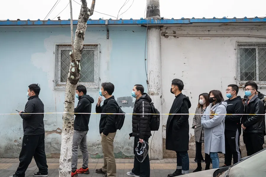 People wait in line outside a Covid-19 vaccination centre in Beijing, China, on 17 March 2021. (Yan Cong/Bloomberg)