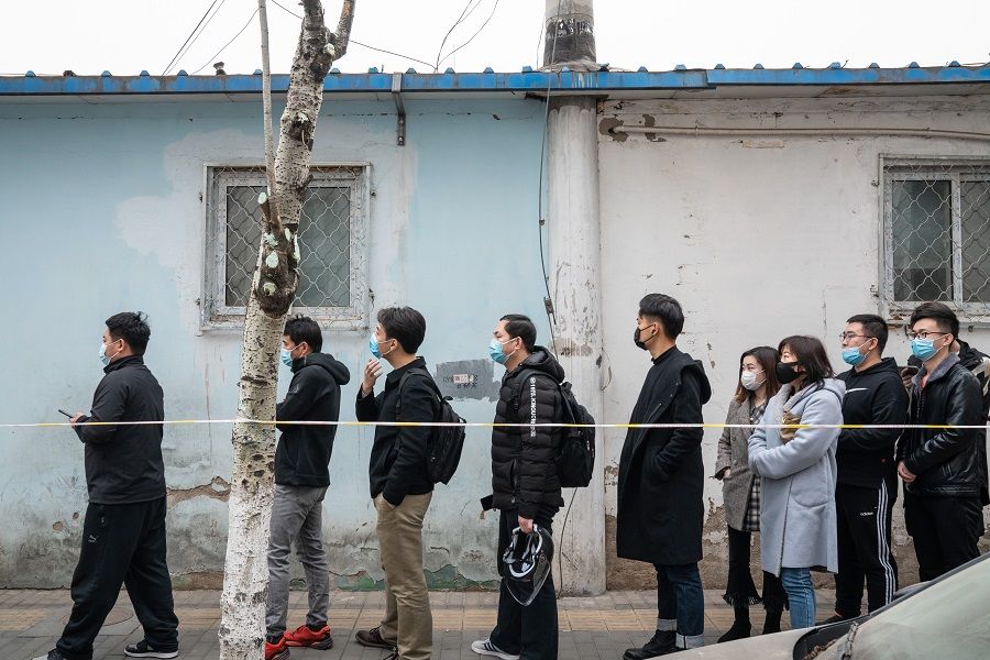 People wait in line outside a Covid-19 vaccination centre in Beijing, China, on 17 March 2021. (Yan Cong/Bloomberg)