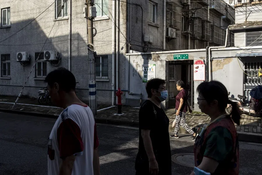 Residents walk through a street in an older neighborhood in Shanghai, China on 30 August 2021.(Qilai Shen/Bloomberg)