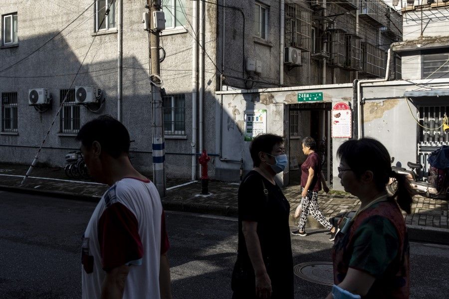 Residents walk through a street in an older neighborhood in Shanghai, China on 30 August 2021.(Qilai Shen/Bloomberg)