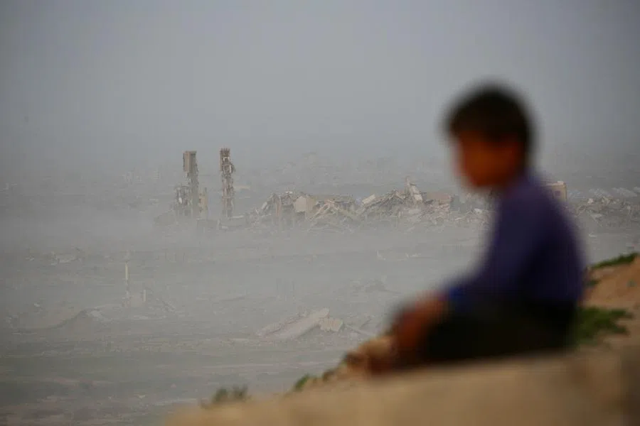 A young boy sits overlooking destroyed buildings at Nuseirat camp for Palestinian refugees in the central Gaza Strip on 31 January 2026. (Eyad Baba/AFP)