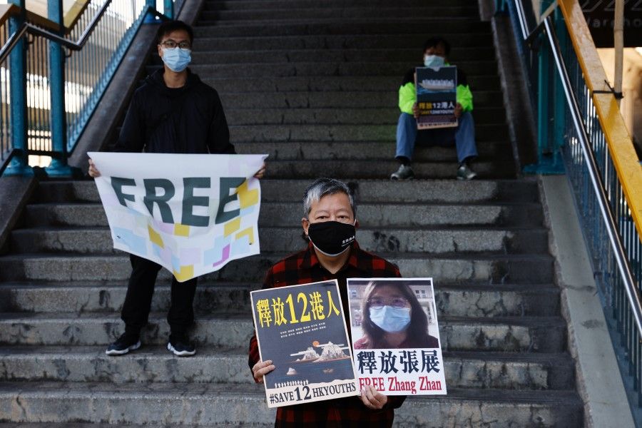 Pro-democracy supporters protest to urge for the release of 12 Hong Kong activists arrested as they reportedly sailed to Taiwan for political asylum and citizen journalist Zhang Zhan outside China's Liaison Office, in Hong Kong, China, 28 December 2020. (Tyrone Siu/REUTERS)