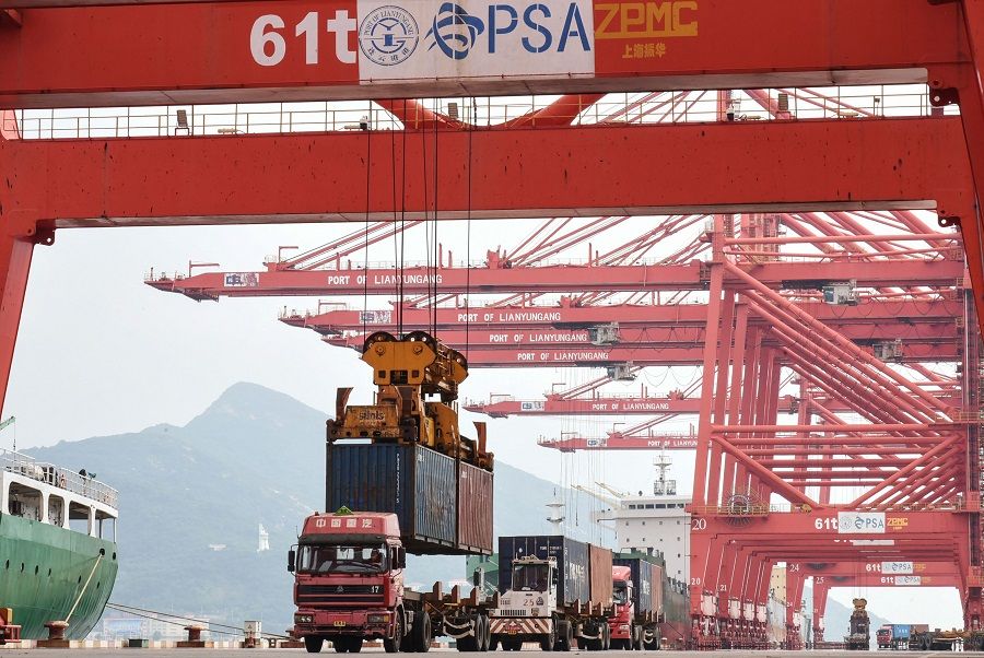 A crane loads a container onto a truck at Lianyungang Port in Lianyungang, Jiangsu province, China, 7 September 2021. (STR/AFP)